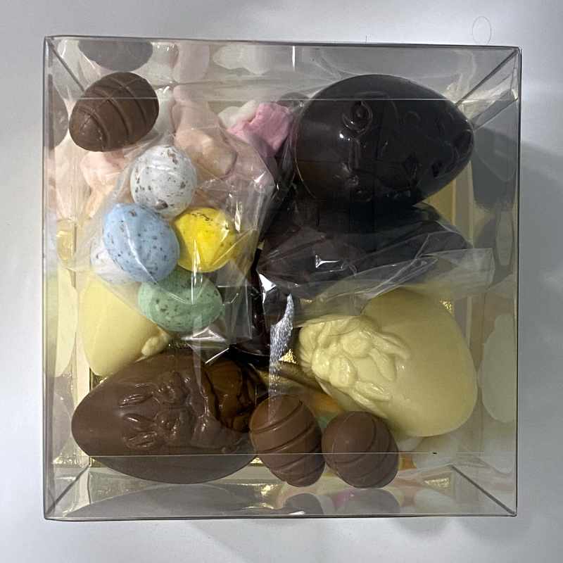 bovenzicht van de box met chocolade eieren, gekleurde en gespikkelde eieren