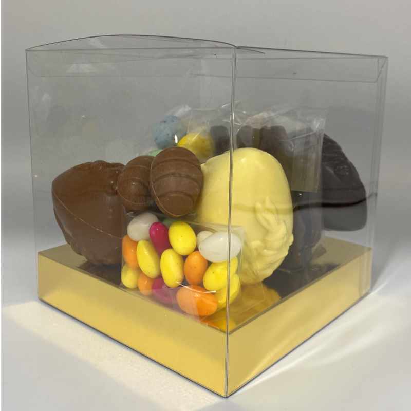 frontaal zicht op de box met suikereitjes, chocolade eieren en een gouden bodem